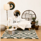A Boston Terrier in a bathrobe relaxing on a luxury white plush pet sofa in a decorated living room.