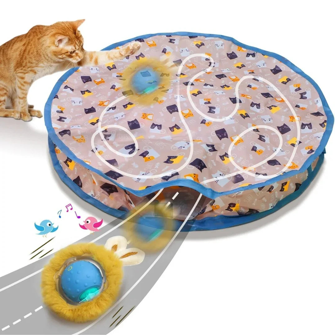 Orange cat playing with a round interactive cat toy mat featuring a moving electronic ball and peek-a-boo holes.