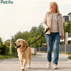 A woman walking her golden retriever on a sunny path using a comfortable, reflective dog leash.