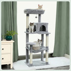 Three cats lounging on a grey multi-level cat tree, which includes a top plush bed, a central cat cave, and a hammock base.
