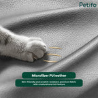 Close-up of a cat's paw touching premium, skin-friendly, and scratch-resistant microfiber PU leather upholstery on a pet sofa.