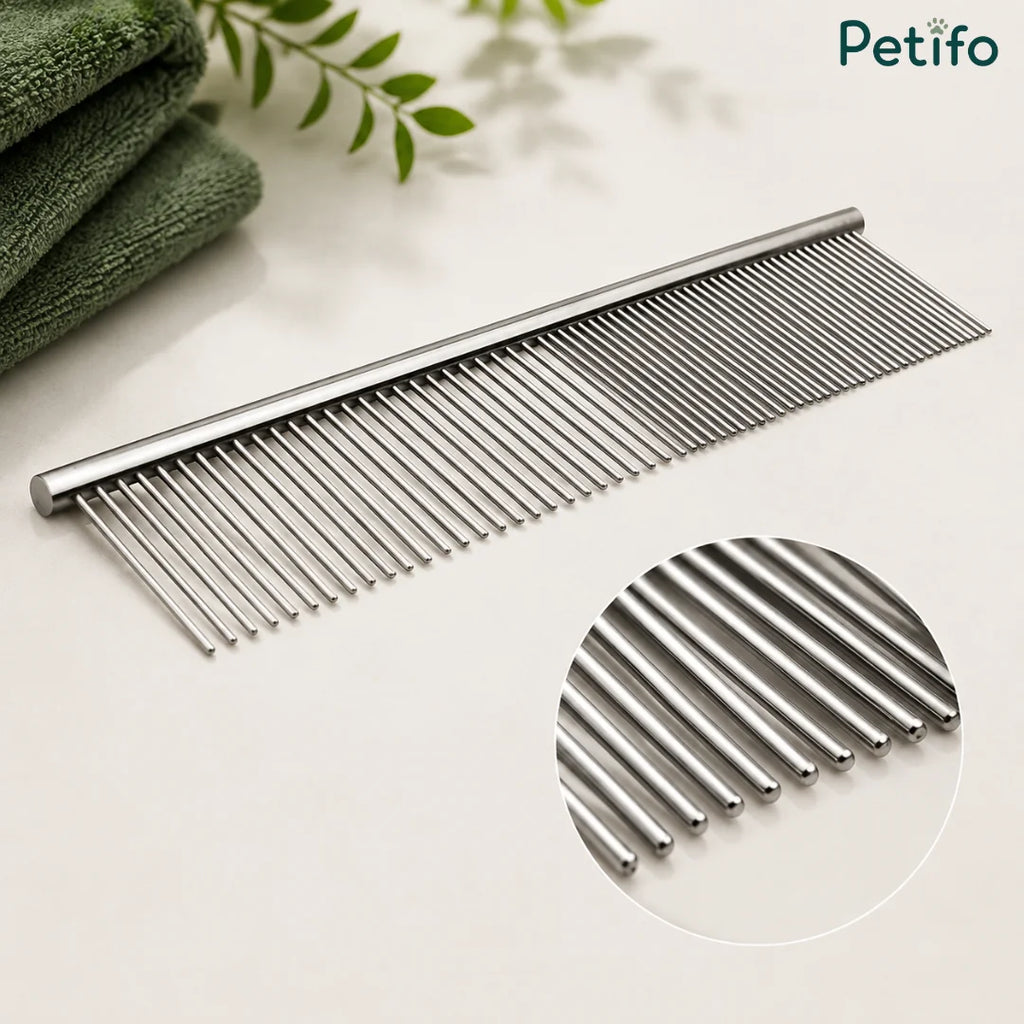 Close-up studio view of the Petifo metal pet grooming comb next to green towels, highlighting its rounded teeth.