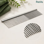 Close-up studio view of the Petifo metal pet grooming comb next to green towels, highlighting its rounded teeth.