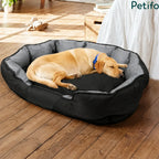 Comfortable large dog sleeping in a cozy black pet bed on a wooden floor.