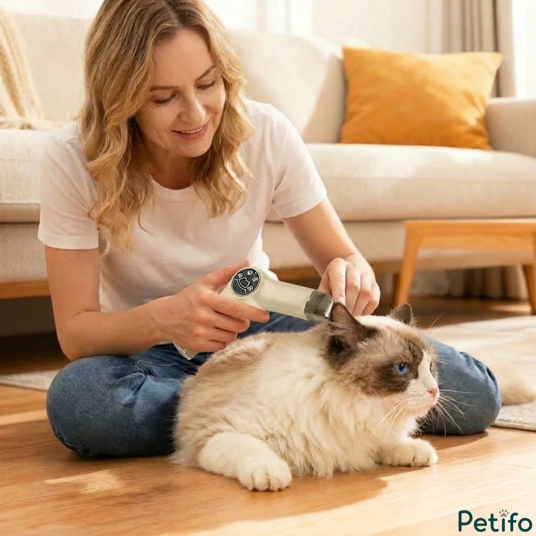 Woman comfortably using a compact cordless pet trimmer to groom a cat's ear area at home.