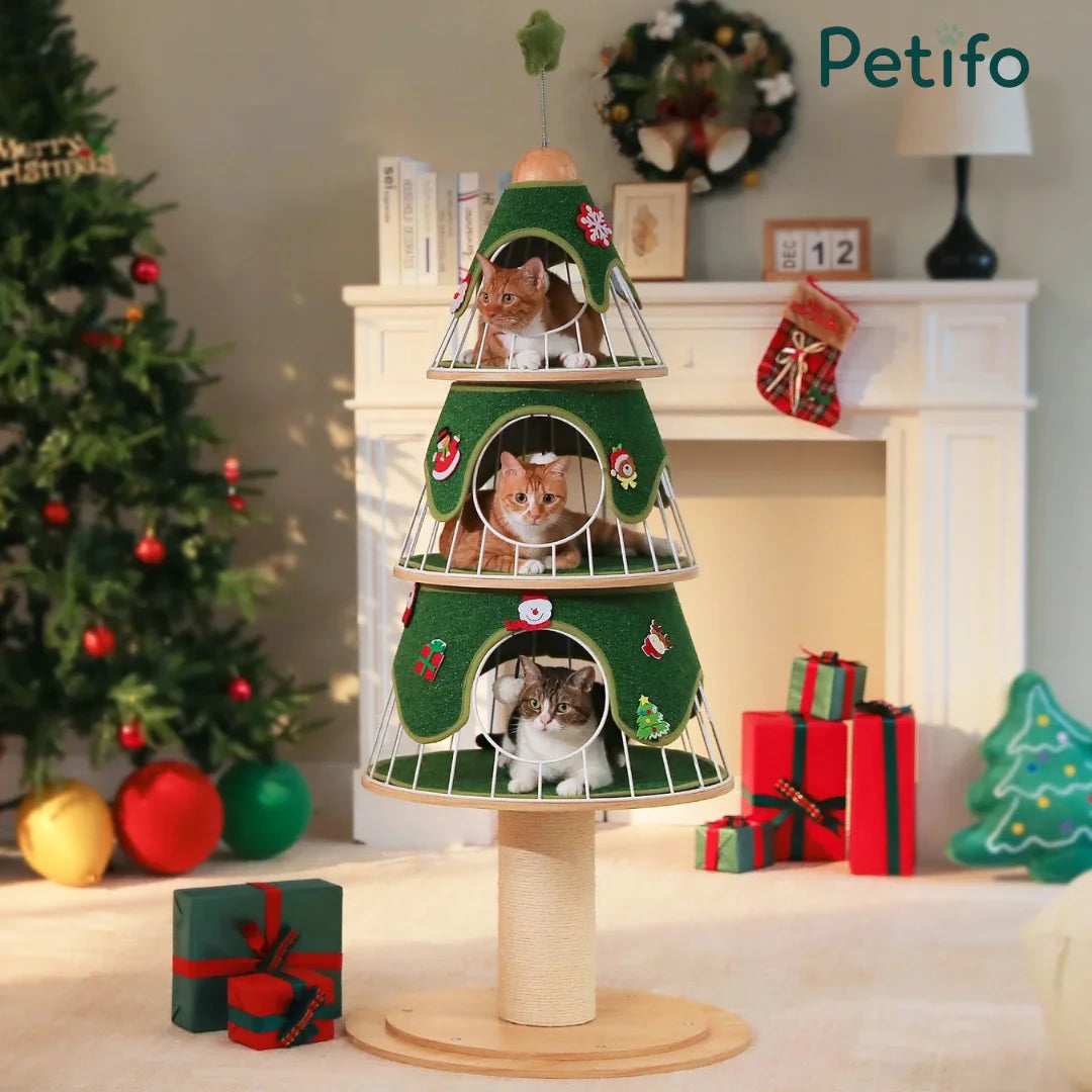 A festive, three-tier green cat tower shaped like a Christmas tree, decorated with ornaments, providing multiple resting levels for three cats.
