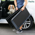 Person demonstrating how to easily carry the lightweight, foldable pet car ramp next to a vehicle.