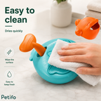 Cleaning demonstration infographic showing a hand wiping the surface of the Petifo treat launcher toy with a white cloth.