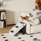 Dog climbing white plastic pet stairs to sofa.