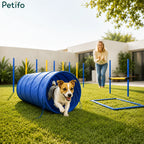 A dog running through a Petifo agility tunnel on a backyard lawn with a pet owner clapping in the background.