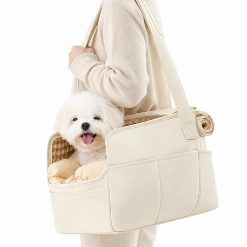 A small white Maltese dog sitting comfortably inside a beige Petifo pet carrier held by a person.