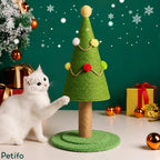 Cute white kitten playing with a festive green Christmas tree cat scratcher surrounded by holiday gifts and snowflakes.
