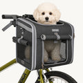 Fluffy white puppy sitting happily inside the Petfuled bicycle pet bag mounted on a green bike.