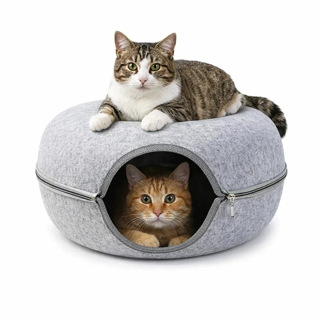 Two cats relaxing together inside and on top of a gray felt tunnel bed.