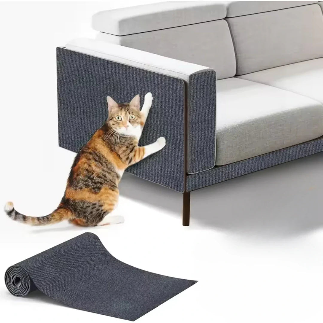 Studio product shot showing a calico cat scratching a grey Petifo cat scratch mat applied to the armrest of a modern sofa, with an unrolled mat in the foreground.