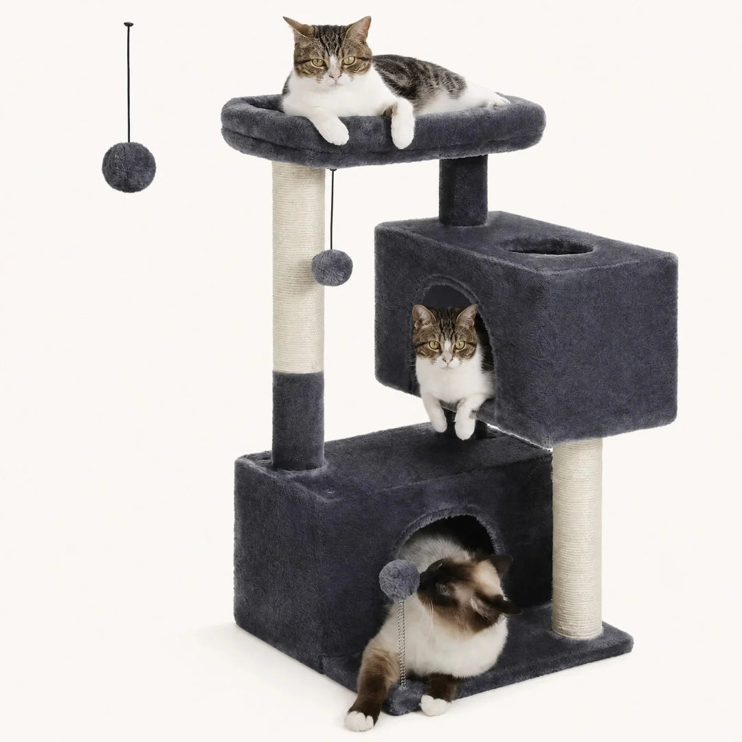 Three cats relaxing on a multi-level plush dark grey cat tree with scratching posts and dangling toys.