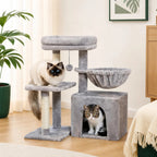 A grey plush multi-level cat tree featuring a square enclosed condo, a suspended side hammock basket, a top resting perch with a hanging toy, and sisal-wraped scratching posts.