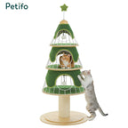 A green, three-tier Christmas tree-themed cat tower featuring hanging play toys and two cats interacting with the structure.