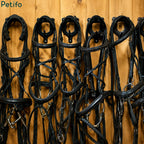 Close-up of multiple black leather horse bridles neatly hanging on wall-mounted tack racks.