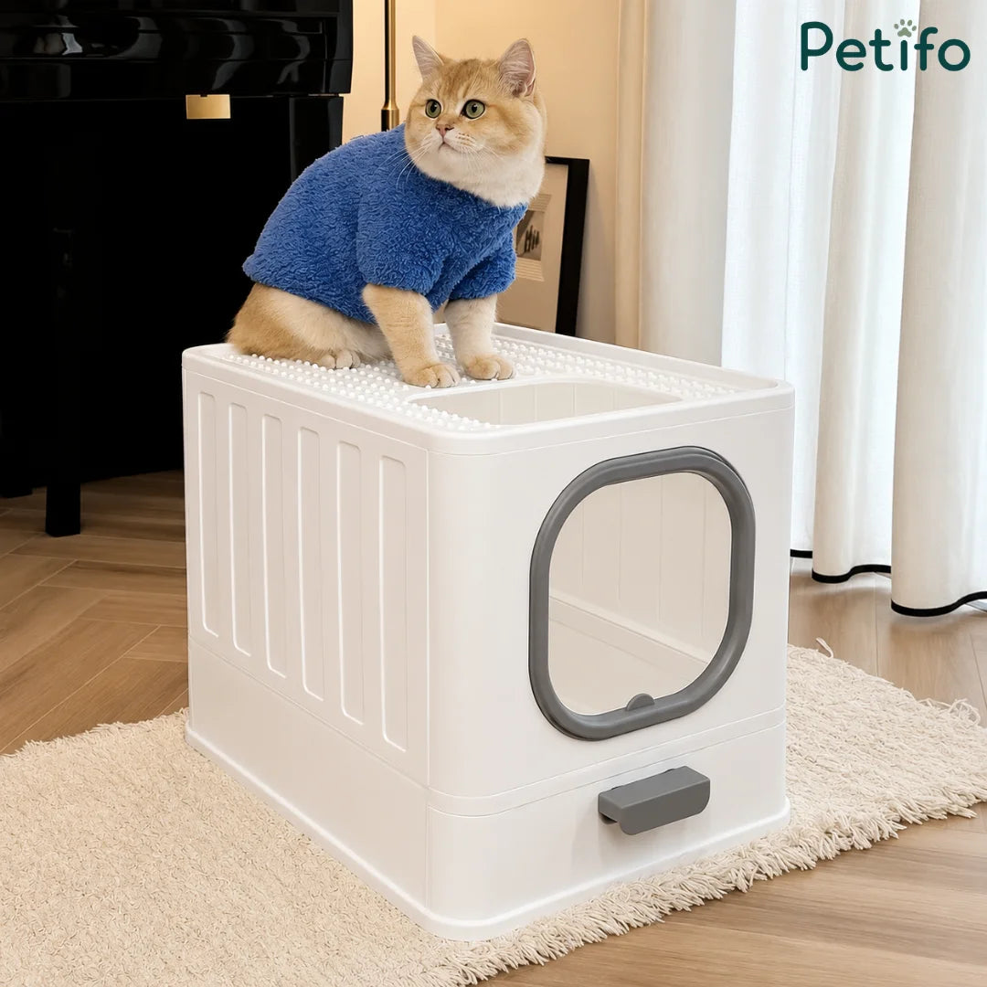 A cat sitting on top of a modern white litter box with a grated surface to help catch loose litter.