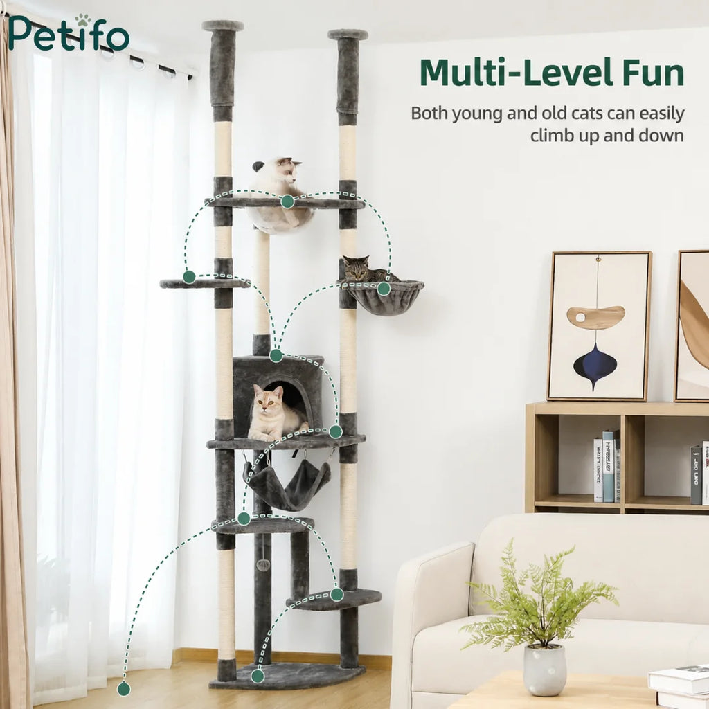 A multi-level grey cat tower in a modern living room designed with various platforms for both young and old cats to climb.
