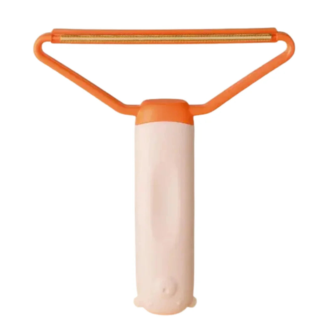 Peach-colored lint remover tool with an orange triangular head and golden scraper edge.