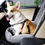 A corgi dog enjoying a safe and relaxed ride while sitting in a grey, plush Petifo pet car seat installed in a vehicle.