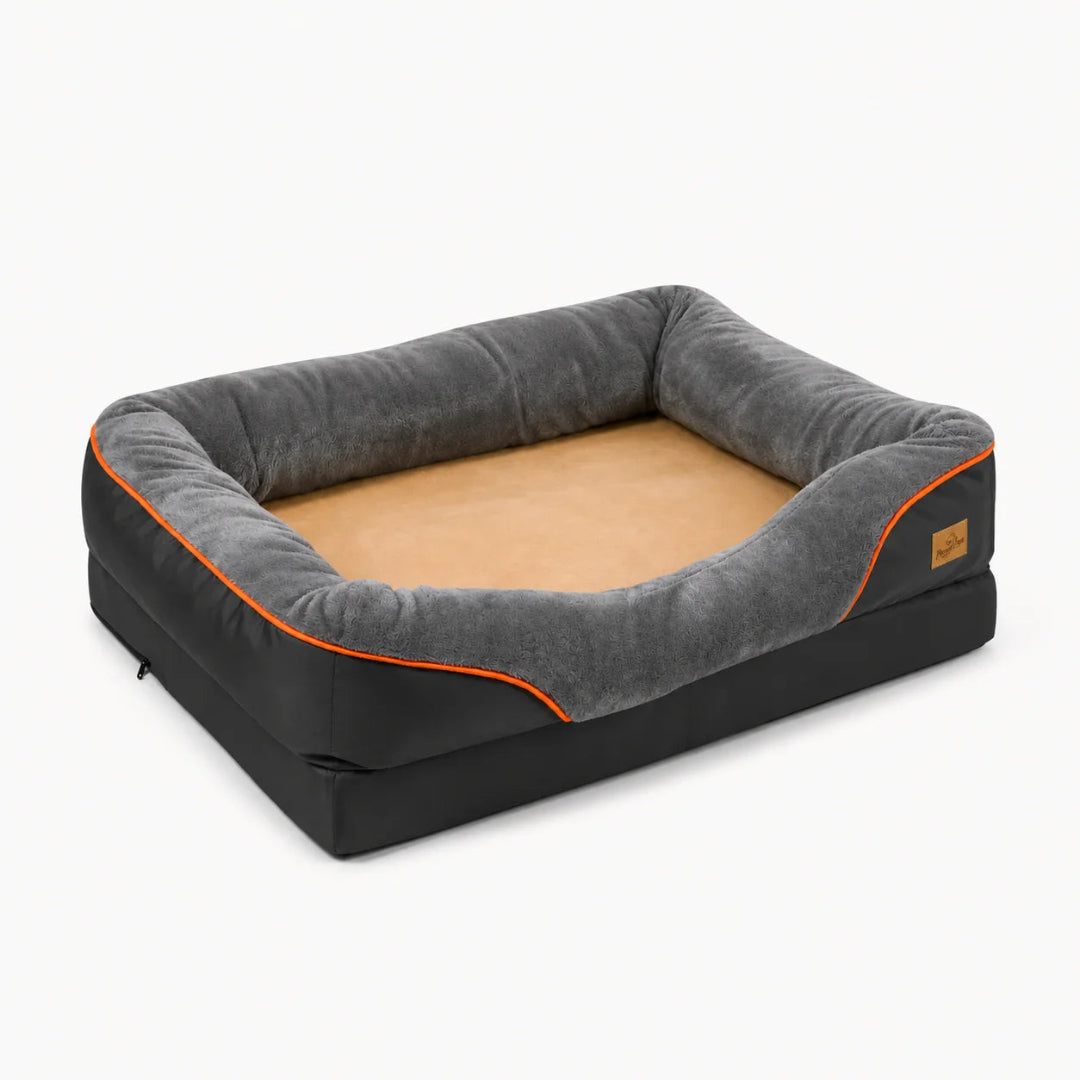 A sleek, rectangular orthopedic dog bed in charcoal grey with an orange accent trim and a plush, tan-colored sleeping surface
