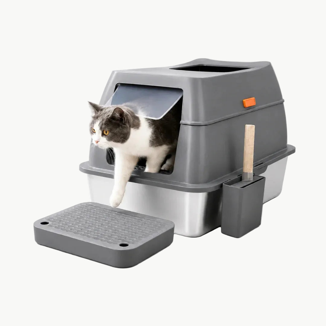 A cat exiting a modern, covered stainless steel litter box with a grey hood, door, and matching litter-trapping mat.
