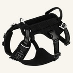 This black  tactical-style dog harness features reflective stitching, durable buckles, an integrated handle.