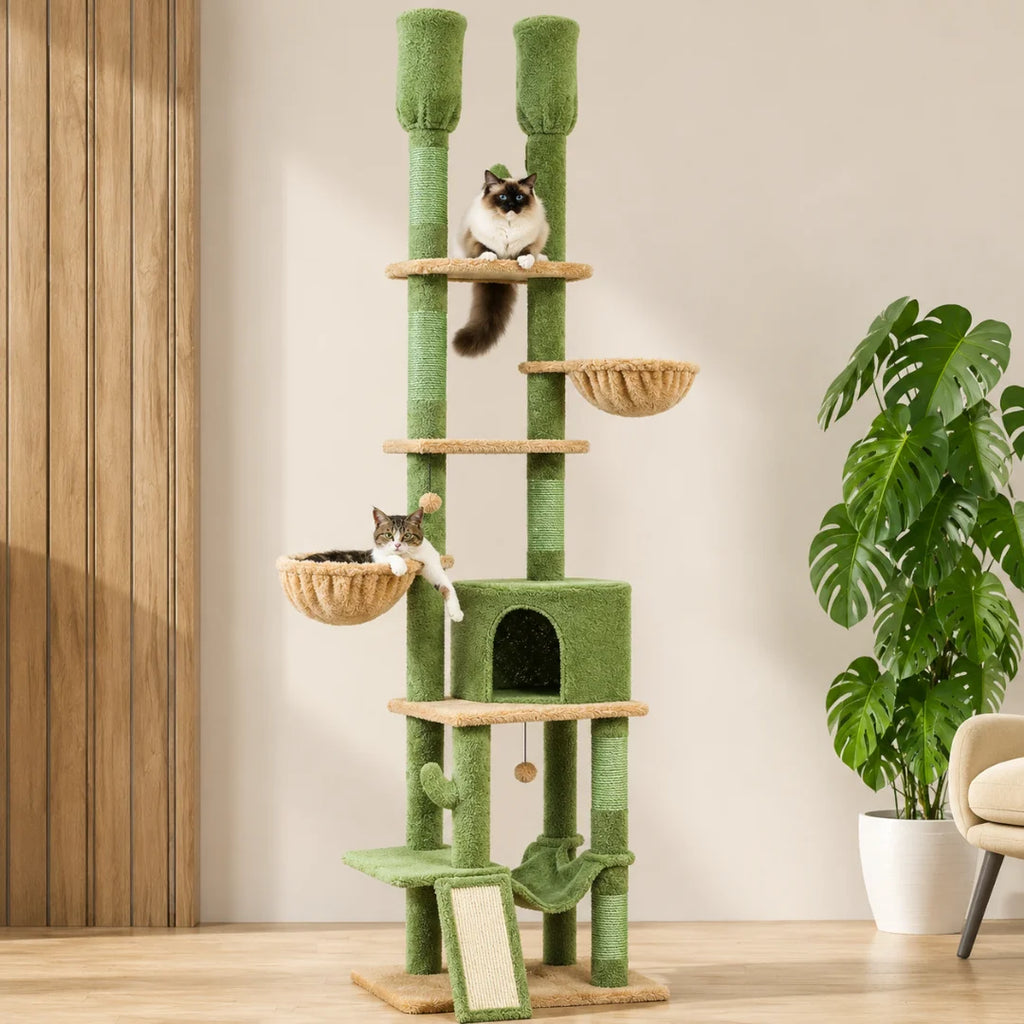 Tall green multi-level cactus-themed cat tree with two cats relaxing in perches and a condo in a modern living room.
