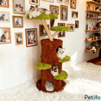 Three fluffy cats resting on a multi-level tree-shaped cat tower with plush green platforms and a brown climbing structure.
