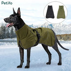 Black dog standing in a snowy landscape wearing an olive green weather-resistant dog jacket with color options displayed.