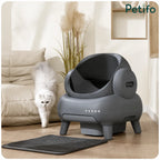 White fluffy cat walking past a sleek grey Neakasa self-cleaning litter box in a modern living room setting.