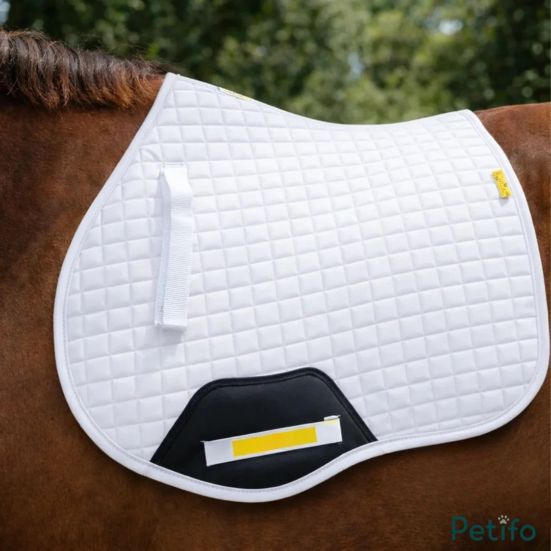 White quilted saddle pad placed on the back of a brown horse.