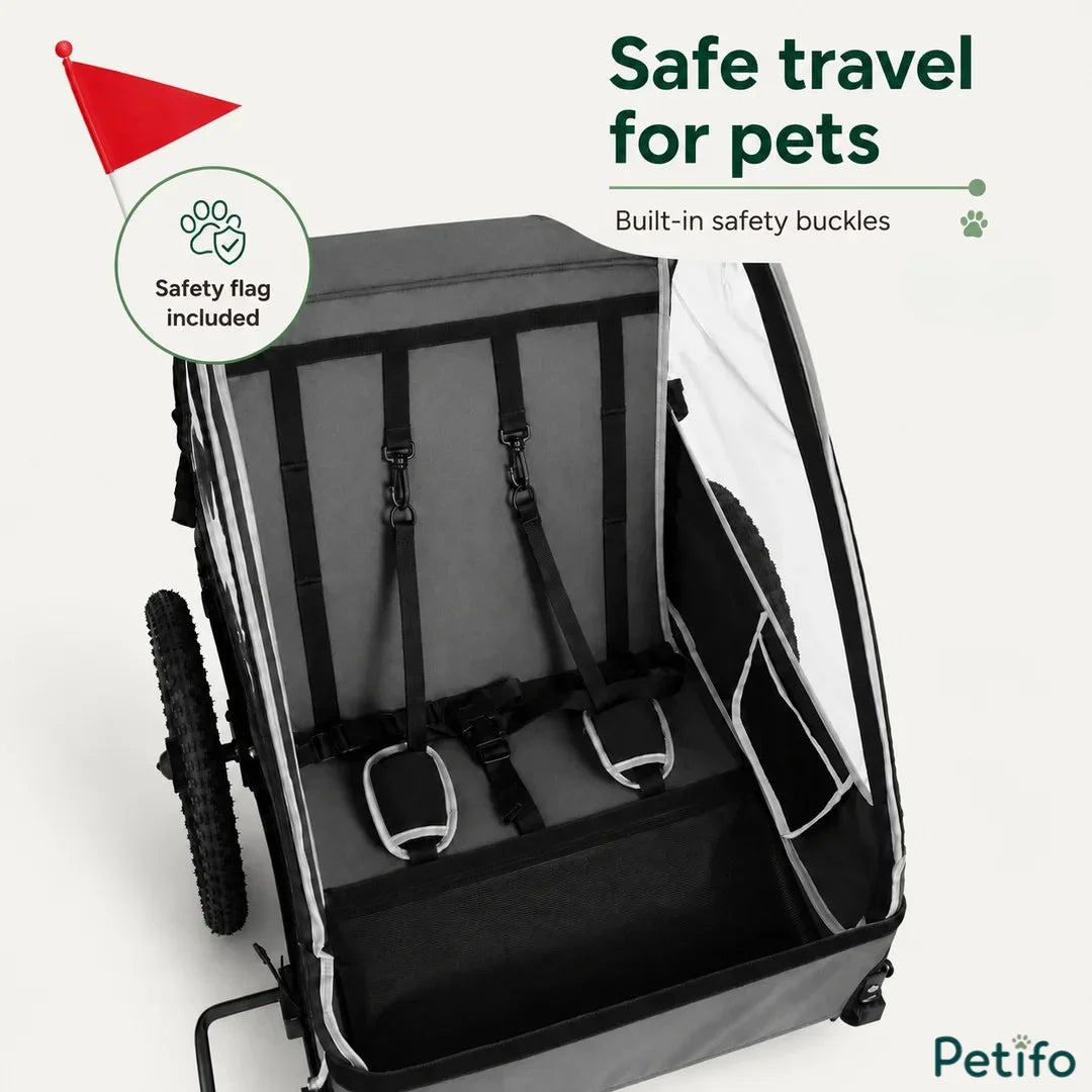 The interior of a pet bike trailer featuring built-in safety buckles and a high-visibility safety flag for secure travel.
