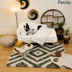 A Boston Terrier in a bathrobe relaxing on a luxury white plush pet sofa in a decorated living room.